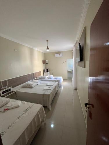 a hotel room with two beds and a hallway at Hotel Quintino - Metrô Sé -localizado no coração de São Paulo Próximo 10 minutos do Brás 5 minutos da 25 de Março e com estacionamento no local grátis in Sao Paulo