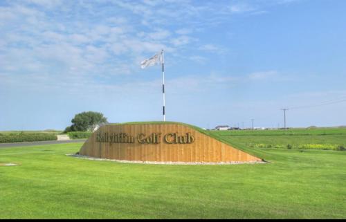 a sign in a field with a flag on top of it at Bernie’s Place in Ballyliffin