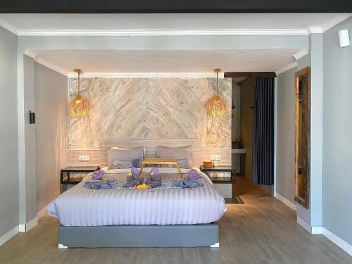 a bedroom with a large bed with flowers on it at The Jungle Hostel Canggu in Canggu