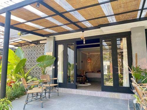 an open patio with chairs and a roof at The Jungle Hostel Canggu in Canggu