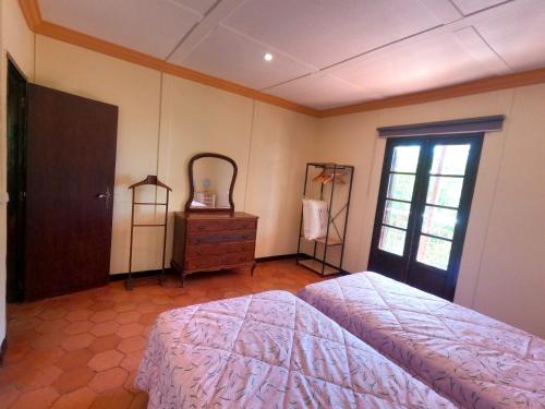 a bedroom with a bed and a dresser and a window at Almada T4, Lazarim, Caparica in Almada