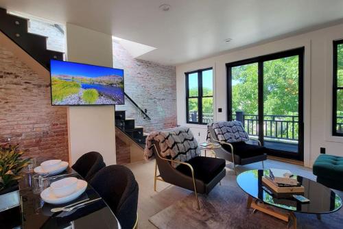 a living room with a tv on a brick wall at Station House Suite A in Jacksonville