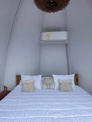 a large white bed with four pillows on it at MACA GLAMPING in Calima