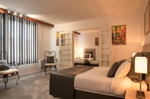 una habitación de hotel con una cama grande y una habitación con un dormitorio en The Originals Boutique, Hôtel Clos Sainte Marie, Nevers (Inter-Hotel), en Nevers