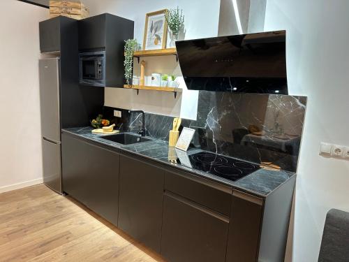a kitchen with black cabinets and a counter top at Bear Homes - Olimpia Suite in Valencia