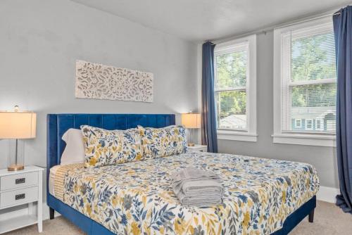 um quarto com uma cama azul e 2 janelas em BRAND NEW, Private Parking, Stylish 3bedroom house em Pittsburgh
