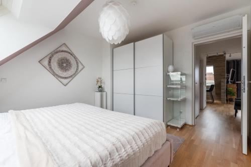 ウィーンにあるLuxurious living with beautiful terraceのベッドルーム(白いベッド1台、シャンデリア付)
