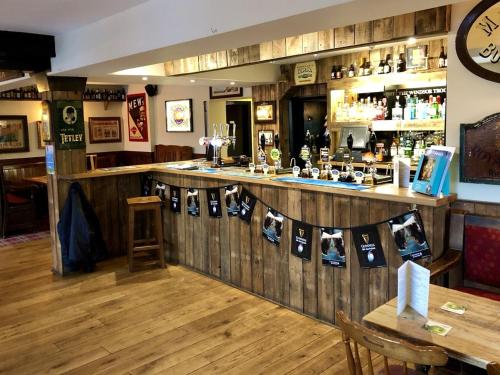 eine Bar in einem Restaurant mit Holzwand in der Unterkunft The Windsor Trooper Pub & Inn in Windsor