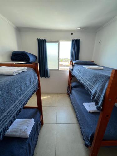 a room with three bunk beds and a window at Nuevo apartamento en primer piso a 7 min del centro in Concordia