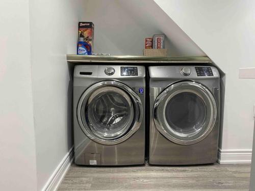 a washer and dryer in a corner of a room at Adorable 2-Bedroom Basement with Sep Entrance in Ajax