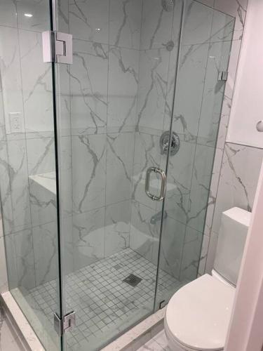 a bathroom with a glass shower with a toilet at Adorable 2-Bedroom Basement with Sep Entrance in Ajax