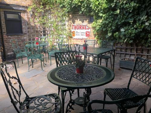 an outdoor table with chairs and a table with a plant at The Windsor Trooper Pub & Inn in Windsor