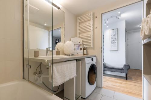 y baño con lavadora y lavamanos. en Luxurious living with beautiful terrace, en Viena