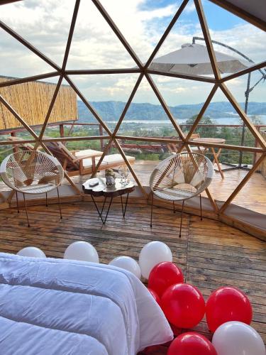 a room with a bed and a table with red and white balloons at MACA GLAMPING in Calima