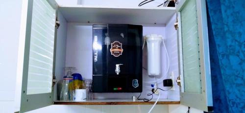 einem Küchenschrank mit schwarzem Gerät in der Unterkunft Beautiful 1 BHK With Pool Wi-Fi Cooking Gas Gym Caretakers in Velha Goa