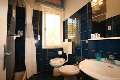 a blue tiled bathroom with a toilet and a sink at A pochi passi dal mare con bellissima vista in Marina di Castagneto Carducci