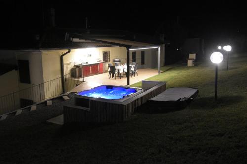 a backyard at night with a swimming pool and a house at Casavacanzedezza in Montecalvo Versiggia