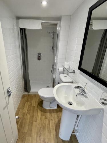 ウィンザーにあるThe Windsor Trooper Pub & Innの洗面台とトイレを備えた白いバスルーム