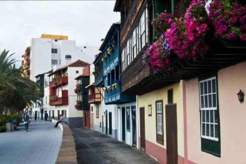 a city street with buildings with flowers on the balconies at ÉPOCA in Santa Cruz de la Palma