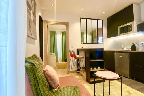 a living room with a green chair and a kitchen at Cosy et joli appartement à Saint-Maurice in Saint-Maurice