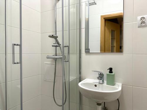 a bathroom with a sink and a shower at MMRent Citrus Room in Gdańsk