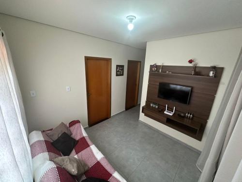 Hospedagem Caconde Ar condicionado - Wi-fi - Garagem في كاكوند: غرفة معيشة مع أريكة وتلفزيون بشاشة مسطحة