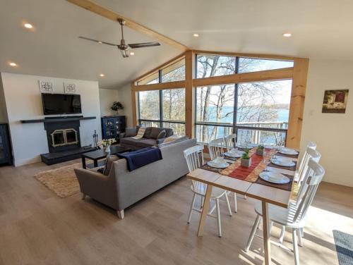 een woonkamer met een bank en een tafel bij Stunning lakefront 4 season cottage in PEC in Bongard