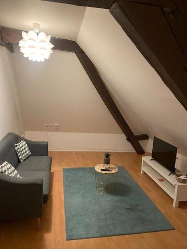 a living room with a couch and a table at Appartement Le Jad'Vert à 200 m du château in Gien