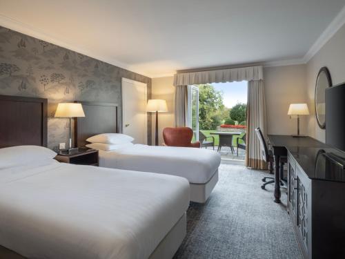 um quarto de hotel com duas camas e uma secretária em Delta Hotels by Marriott St Pierre Country Club em Chepstow