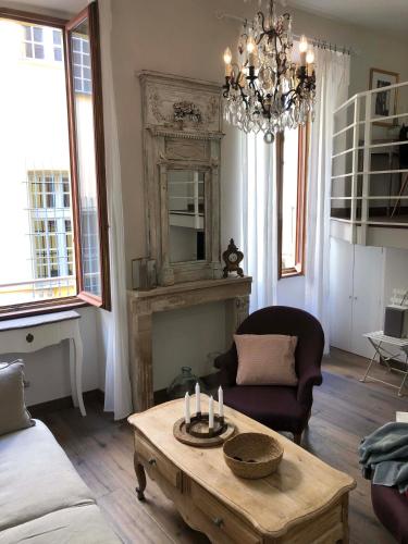 - un salon avec une table basse et un lustre dans l'établissement Petit Palace in Old Nice, à Nice