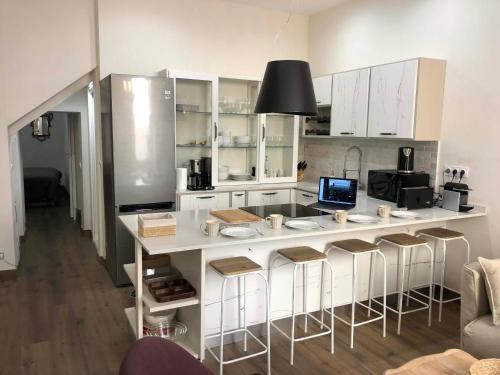 une cuisine avec un grand comptoir blanc et des tabourets de bar dans l'établissement Petit Palace in Old Nice, à Nice