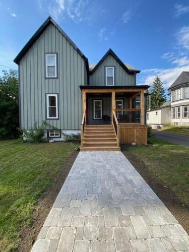 a large green house with a stone walkway in front of it at Downtown Picton 3 bedroom in Picton