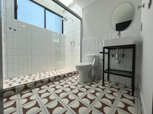 a bathroom with a toilet and tiled walls at Suite a 15 minutos de Polanco y Santa Fe in Mexico City