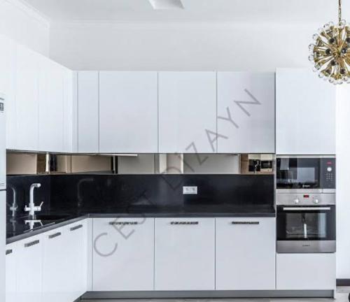 a white kitchen with white cabinets and appliances at Kılıc apartmanı in Istanbul