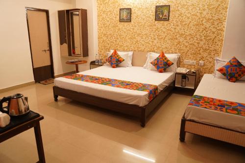 a hotel room with two beds and a table and a bedsenalsenalsenalsenal at Hotel Omni Plaza in Jodhpur