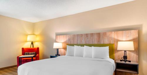 a hotel room with a large bed and a red chair at Country Inn & Suites by Radisson, Atlanta Galleria-Ballpark, GA in Atlanta