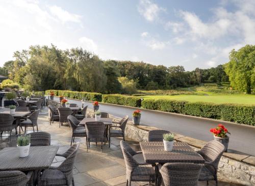 a row of tables and chairs on a patio at Delta Hotels by Marriott St Pierre Country Club in Chepstow