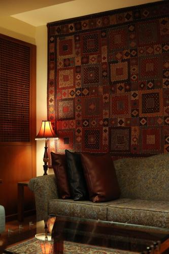 a couch in a room with a wall with a rug at Le Cedrus Hotel in Al Arz