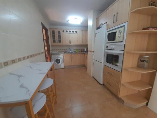 a kitchen with a table and a white refrigerator at La casita de carmen in Cazorla