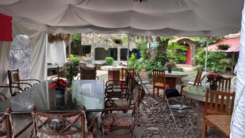 un patio con mesas y sillas bajo una tienda de campaña en LA CASA DE LOS MANGOS AJIJIC en San Antonio