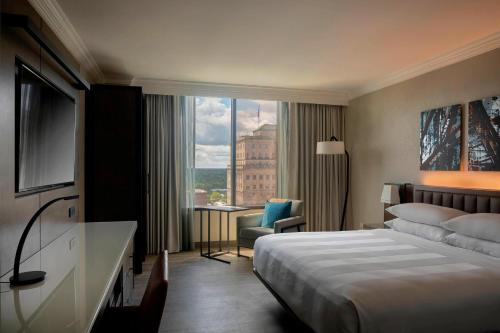 een hotelkamer met een bed en een groot raam bij Winston-Salem Marriott in Winston-Salem