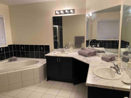 łazienka z 2 umywalkami oraz wanną i wanną w obiekcie Adorable Ajax House for Rent w mieście Ajax
