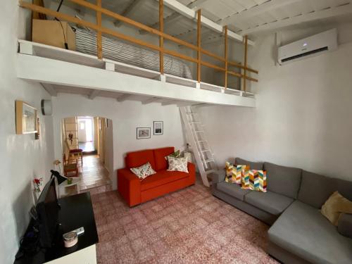 uma sala de estar com um sofá e uma cama alta em Casa na aldeia em Albernoa