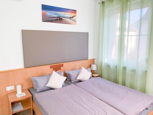 um quarto com uma cama com lençóis azuis e uma janela em Hotel Post em Mühlacker