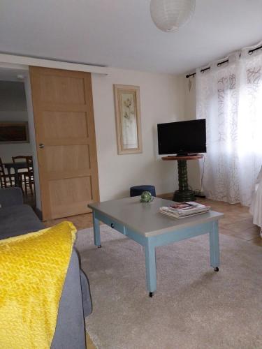 un salon avec une table et une télévision dans l'établissement gîte la Fonderie, à Fréland