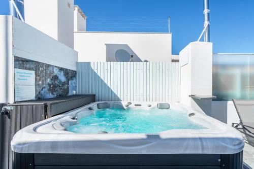 eine Whirlpool-Badewanne mit blauem Wasser in einem Gebäude in der Unterkunft New Luxury Penthouse beachfront in the Algarve in Armação de Pêra