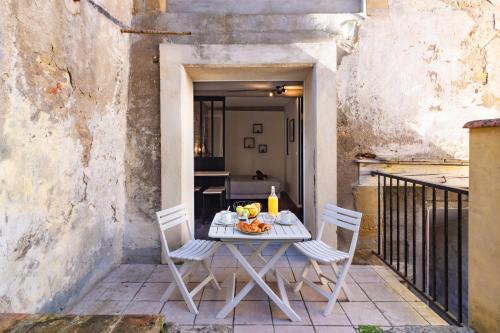 uma mesa branca e cadeiras num pátio com uma mesa em LE COSMO Du Grand Bassin Avec Terrasse em Castelnaudary