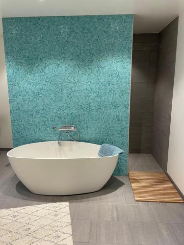 a bath tub in a bathroom with a green wall at Modern cottage in Sogndal