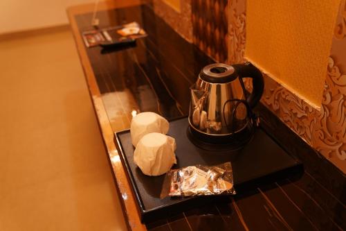 a table with a tea kettle and bread on it at Hotel Omni Plaza in Jodhpur