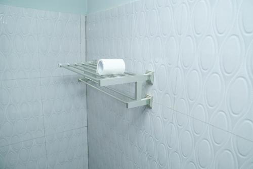 un rouleau de papier toilette sur une étagère dans une salle de bains dans l'établissement SATK INN Jaffna, Kokkuvil, 
